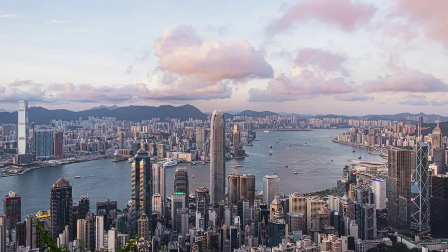 香港天際線日落,粉紅雲朵與海港船隻