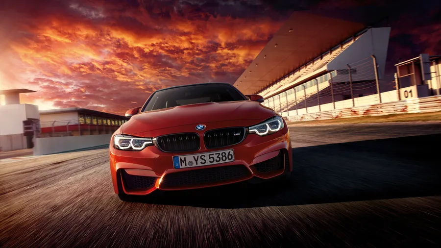 紅色BMW M4在日落時分的賽道上疾馳。