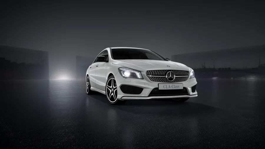 白色Mercedes CLA-Class轎車在夜間霧氣瀰漫潮濕的道路上被照亮。