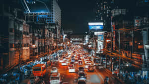 夜晚的城市街道，擠滿汽車和發光的廣告牌。