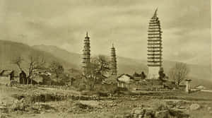 三座歷史悠久的塔樓矗立在一個有石屋和光禿樹木的山村中。
