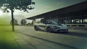 銀色McLaren Speedtail跑車在日落時停泊在現代建築附近。