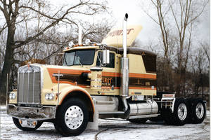 一輛復古Kenworth半掛卡車停在白雪覆蓋的樹林區域。 — 老福特貨車 壁紙