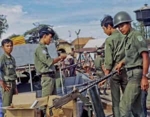 身穿綠色軍裝的士兵在熱帶村莊的船上操作機槍。