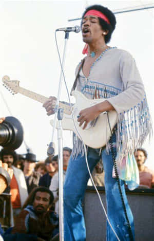 Jimi Hendrix 在舞台上彈奏電結他，背景有觀眾