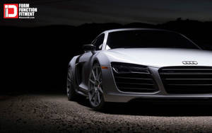 夜間停在碎石上的銀色奧迪R8跑車，背後是黑暗的山脈。 — Audi R8 GIF 壁紙