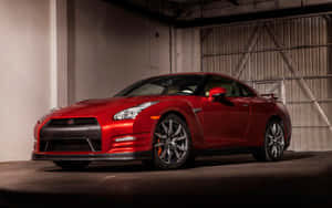 紅色日產GT-R跑車停放在昏暗的工業車庫中。