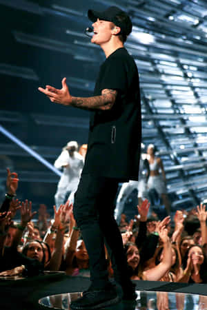 Justin Bieber 在演唱會上為歡呼的粉絲唱歌。