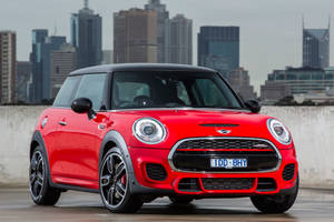 紅色MINI Cooper S停泊在屋頂，俯瞰城市天際線。