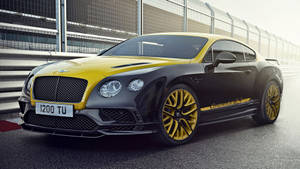 賽道上的黑色和黃色 Bentley Continental GT3。