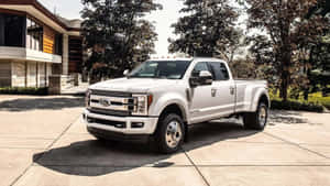 陽光明媚的日子裡，白色福特F-350貨車停在一棟現代化住宅前。