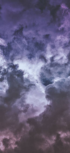 戲劇性的紫色和灰色雲朵在陰鬱的暮色天空中旋轉。