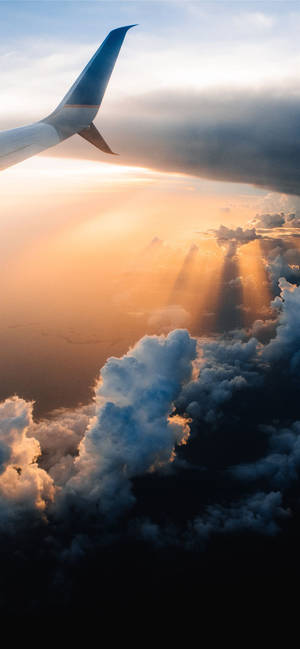 機翼映襯著夕陽雲彩和金色光線