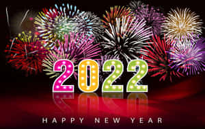 發光的2022年招牌燈，背後有煙火，映在反光的紅色表面上。