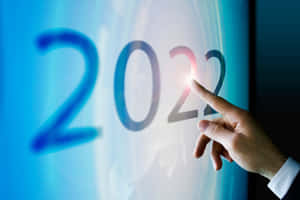 手觸摸一個發光的數碼顯示屏，顯示2022年。