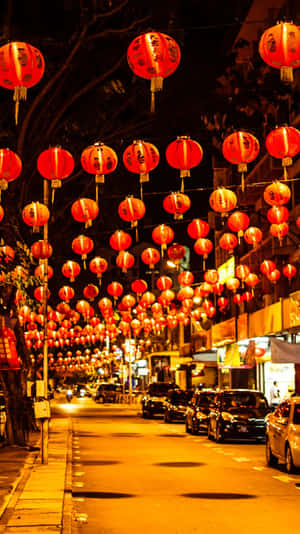 夜晚的街道被發光的紅色燈籠覆蓋，兩旁停有汽車。 — 唐人街 GIF 壁紙