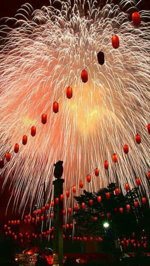 煙火在夜間節日懸掛的紅燈籠行上方爆發。 — 煙火 壁紙