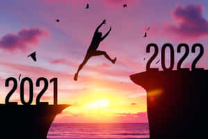 日落時分，人物從標有2021的懸崖跳到標有2022的懸崖。
