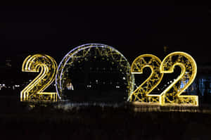夜間新年慶祝活動中照亮的金色 2022 數字和拱門。