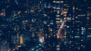從鳥瞰角度看到的夜間城市景觀，帶有發光的窗戶和明亮的街道。 — 夜晚 GIF 壁紙