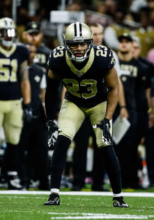 身穿聖徒隊球衣的美式足球員在比賽中蹲伏在場上。 — NFL 美式足球 GIF 壁紙