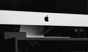 在深色背景下，Apple iMac 標誌在時尚的白色邊框上的特寫。 — 黑白 壁紙