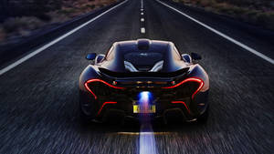 黑色McLaren P1在黃昏時分於沙漠公路上疾馳，帶有發光燈光。