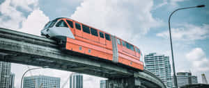 現代城市摩天大樓和多雲天空下，高架軌道上的橙色單軌列車。