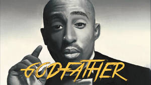 Tupac Shakur 向上指，帶有黃色 'GODFATHER' 文字。 — 說唱歌手 壁紙