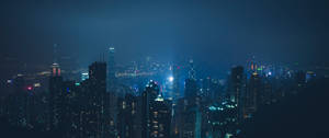 夜間城市天際線，摩天大樓燈火通明，氣氛朦朧。