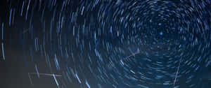 深藍色夜空中以明亮恆星為中心的旋轉星軌。