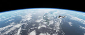太空站繞地球運行，顯示海洋、雲層和星星 — 太空 壁紙