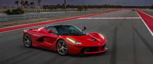 黃昏時分賽道上的紅色法拉利 LaFerrari，背景有棕櫚樹。 — 4K 法拉利 壁紙