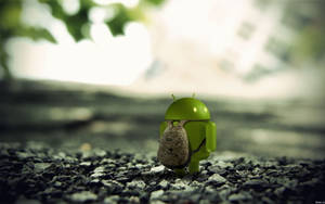 揹著背包的綠色Android公仔站在戶外碎石上。 — 凌志標誌 GIF 壁紙