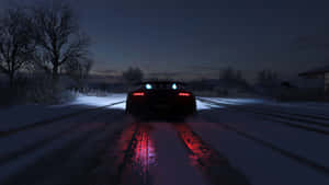 黑色跑車在雪地道路上夜間行駛，紅色尾燈發光。 — 極限競速：地平線4 壁紙