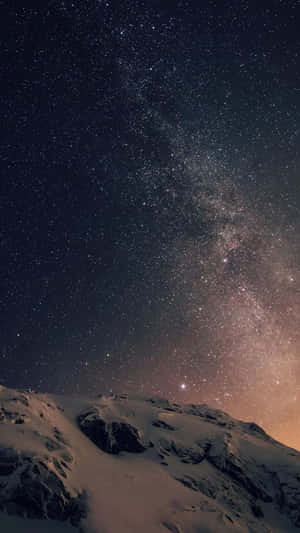 白雪覆蓋的山峰，在充滿活力的星空下，銀河清晰可見。