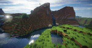 方塊狀的 Minecraft 山脈、河流和一頭牛，在明亮的藍天下。