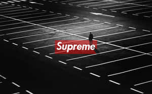 一個孤獨嘅人企喺一個空停車場入面，有一個紅色嘅Supreme標誌。