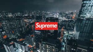 紅色Supreme標誌疊加在夜間城市天際線上，建築物燈火通明。