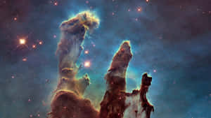 在充滿星星的星雲中，宇宙柱散發著藍色和橙色的色調。 — 銀河 壁紙