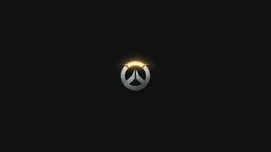 Overwatch標誌在黑色背景上發出金色光芒。