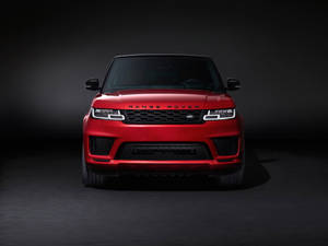 紅色 Range Rover SUV 在攝影棚中，帶有戲劇性燈光。