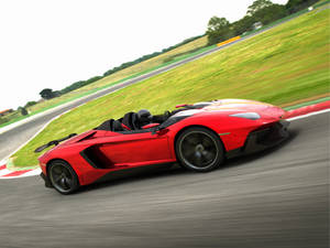 紅色林寶堅尼 Aventador Roadster 在賽道上疾馳，周圍環境模糊呈綠色。
