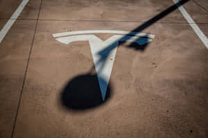 Tesla標誌塗在混凝土上，帶有來自柱子的長影子。