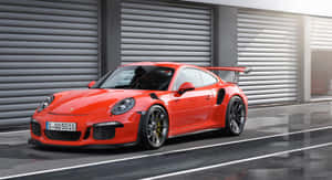 紅色保時捷911 GT2 RS停在潮濕路面的車庫門前。