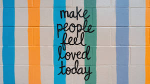 彩色條紋牆壁，帶有手寫勵志訊息 make people feel loved today。