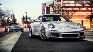 銀色保時捷911 GT3 RS停泊在日落時分的城市街道上。