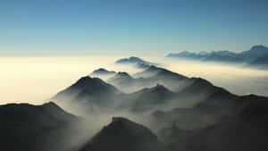 黎明時分，山峰從雲海中浮現，天空清澈湛藍