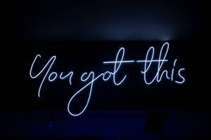 藍色霓虹燈牌在黑暗的房間中顯示 You got this。