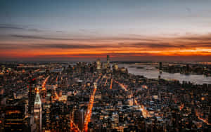 黃昏時分紐約市天際線，帶有橙色夕陽和閃爍的燈光